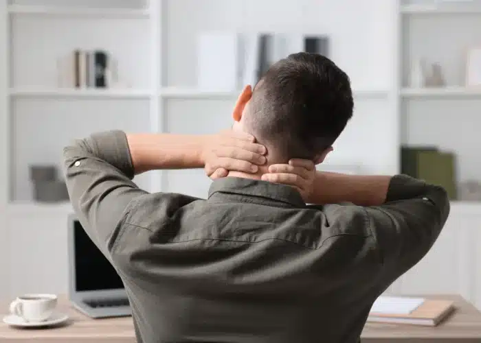 Worker sitting at office desk in pain